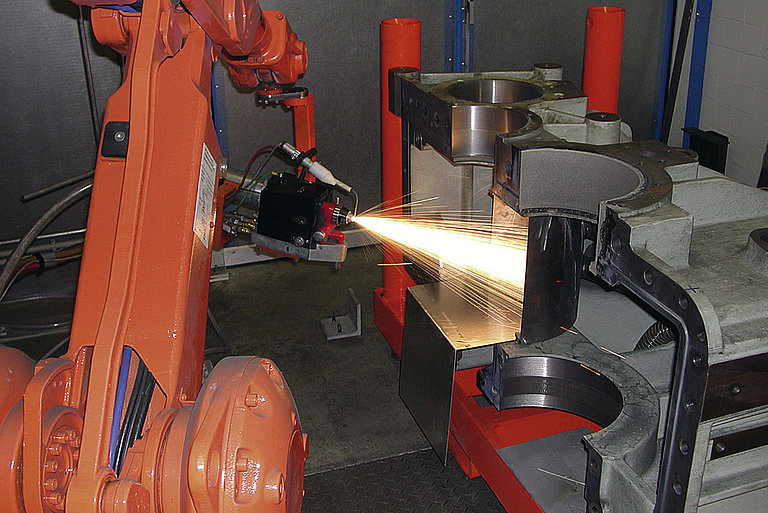 Roboter beim thermischen Aufspritzen eines Bauteils